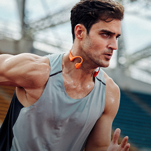 Shop electronics. A man wearing Shokz headphones while running