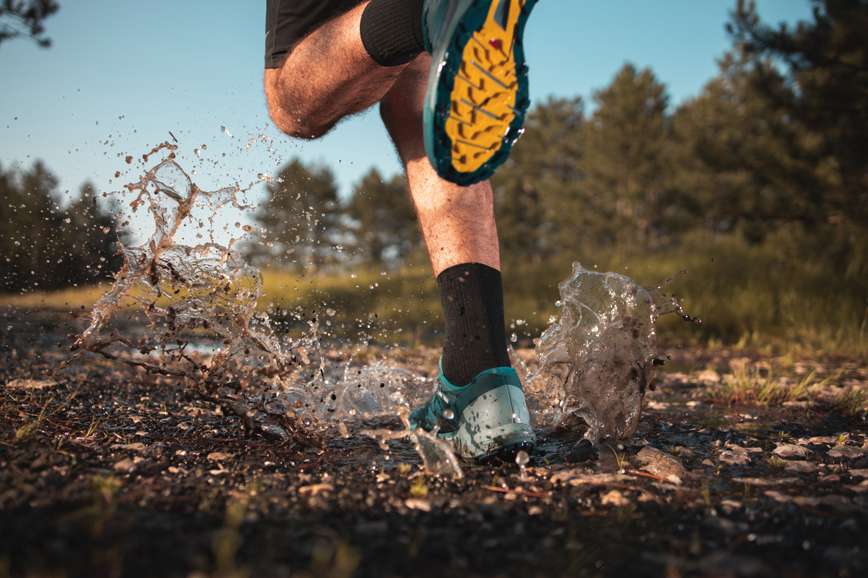 Runner running in the mud and water